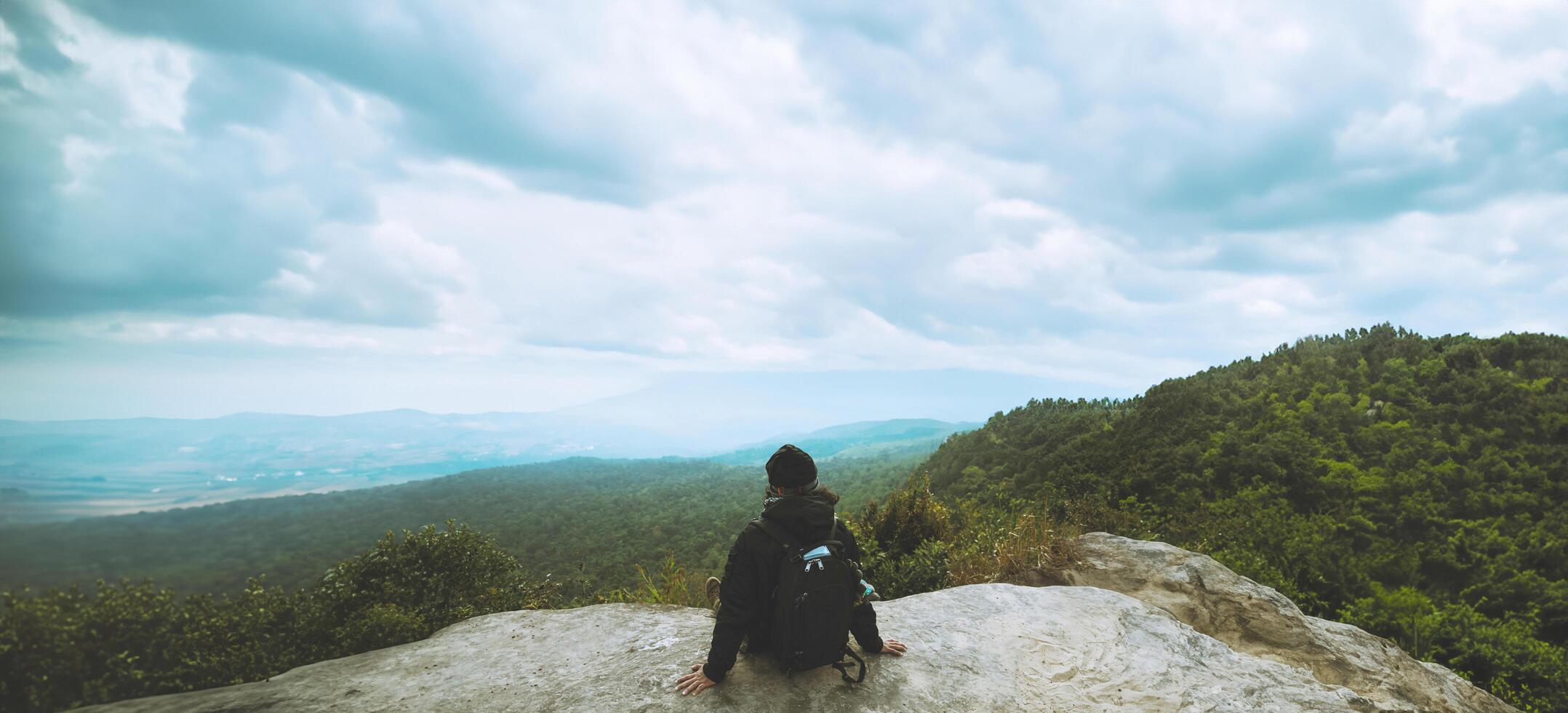 Männer Asiaten Reise entspannen im das Urlaub. bewundern das Atmosphäre Landschaft auf das Berg. Berg Park glücklich. im Thailand foto