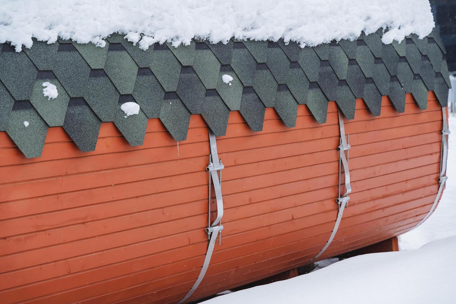 das Seite Mauer von das hölzern Bad Fass. Metall Befestigung von hölzern Mauer. schützend Glasur zum das Dach Dach Ruberoid. foto