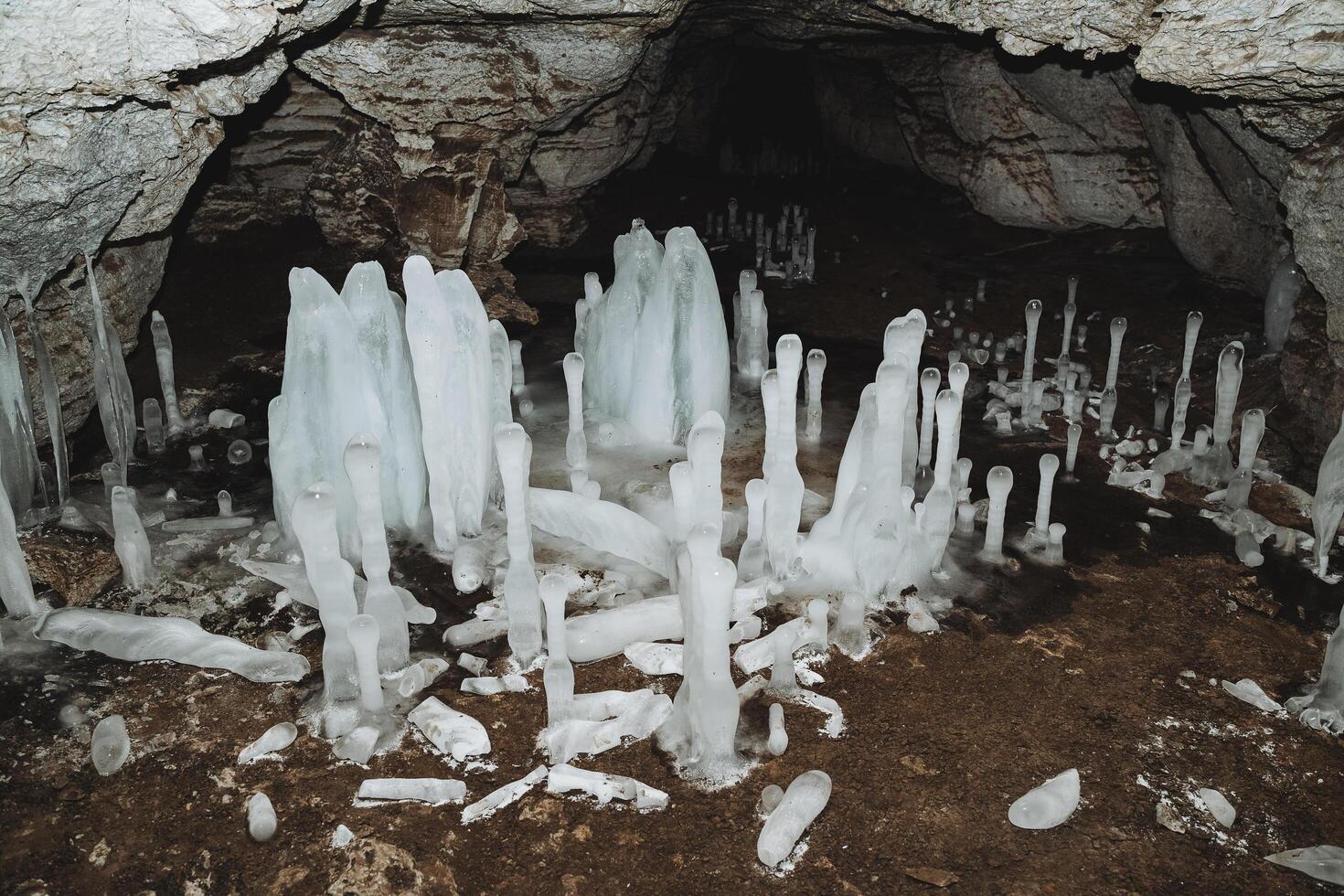 das Höhle im Winter wachsen Eiszapfen, Eis Blöcke auf das Boden, ein Karst Höhle, das Studie von unter Tage Tunnel, Speläologie. foto