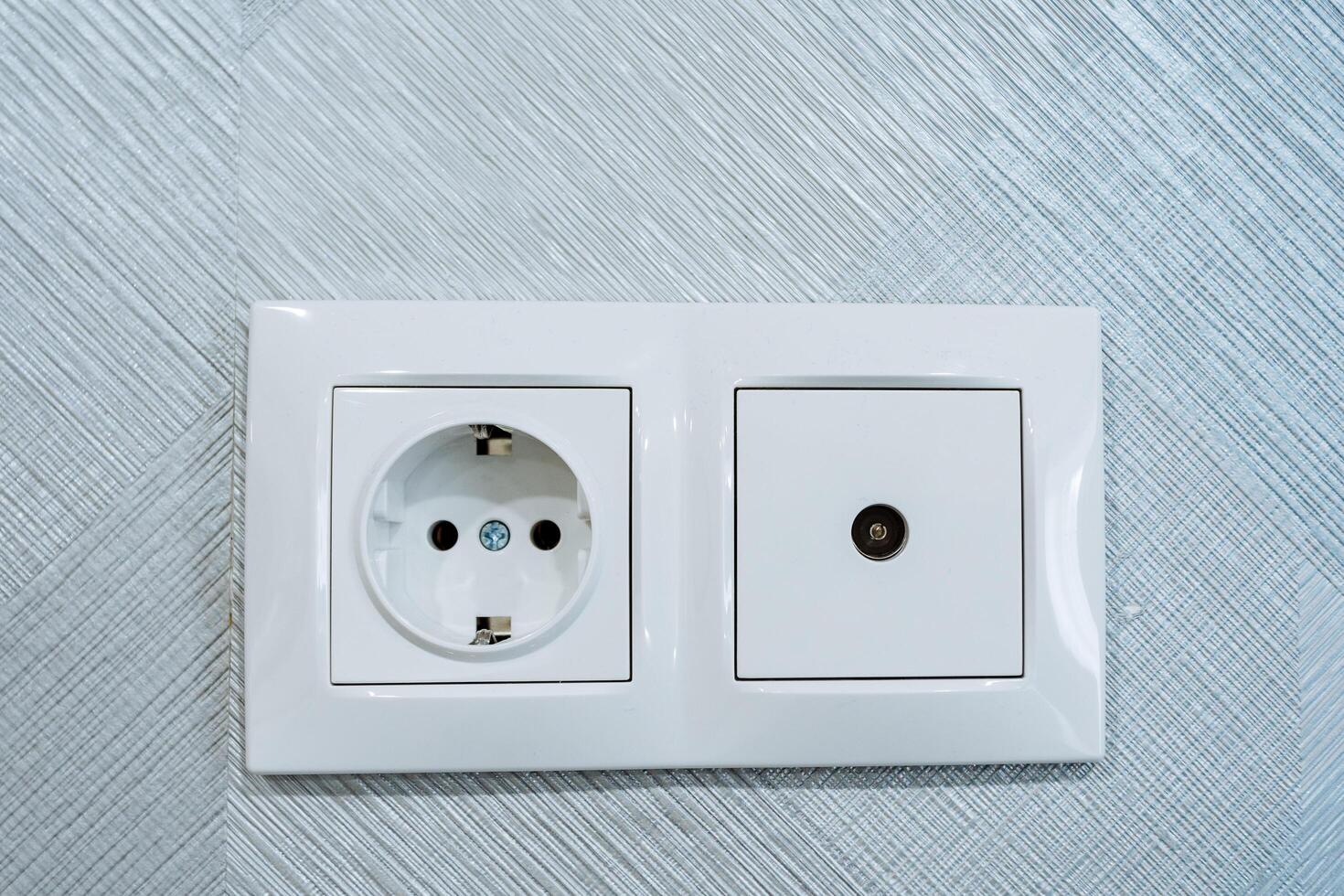 Steckdose kombiniert mit Kabel Steckdose Fernseher, elektrisch Steckdose, Steckdose Eingerichtet auf das Mauer im das Zimmer, Weiß Design von das Panel auf das Stecker von das elektrisch Gerät. foto