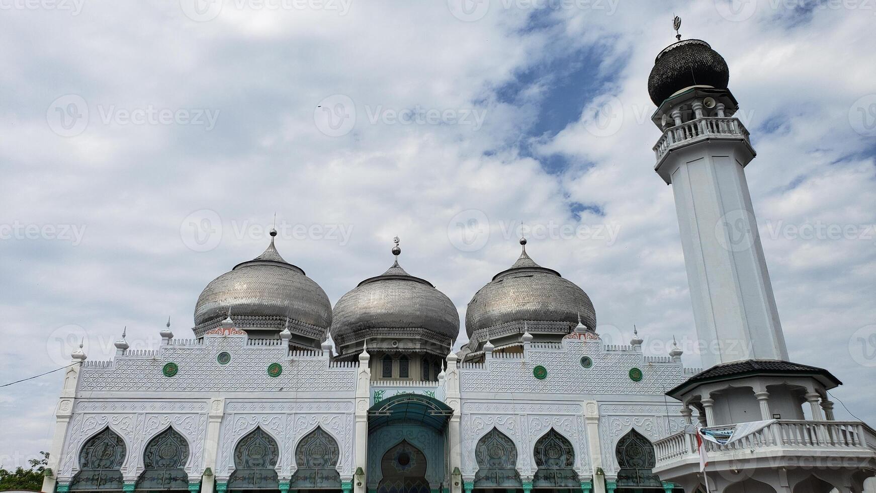 lhokseumawe, Indonesien - - Februar 2024 das Atmosphäre von das al munawwarah großartig Moschee während das Tag mit das Stadt von lhokseumawe foto