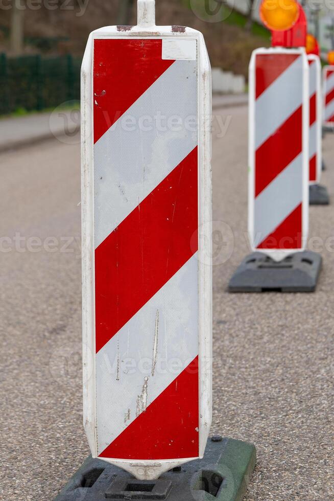Warnung Barriere auf ein Straße im Vorderseite von ein Konstruktion Seite? ˅ foto