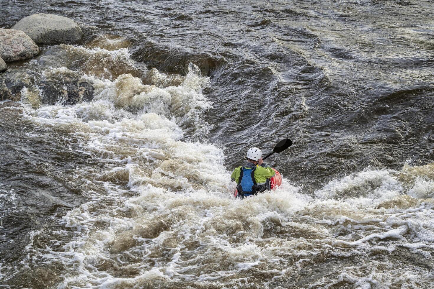 Kajakfahrer Surfen das Welle im Wildwasser Park auf das Puder Fluss im Innenstadt von Fort Collins, Colorado foto