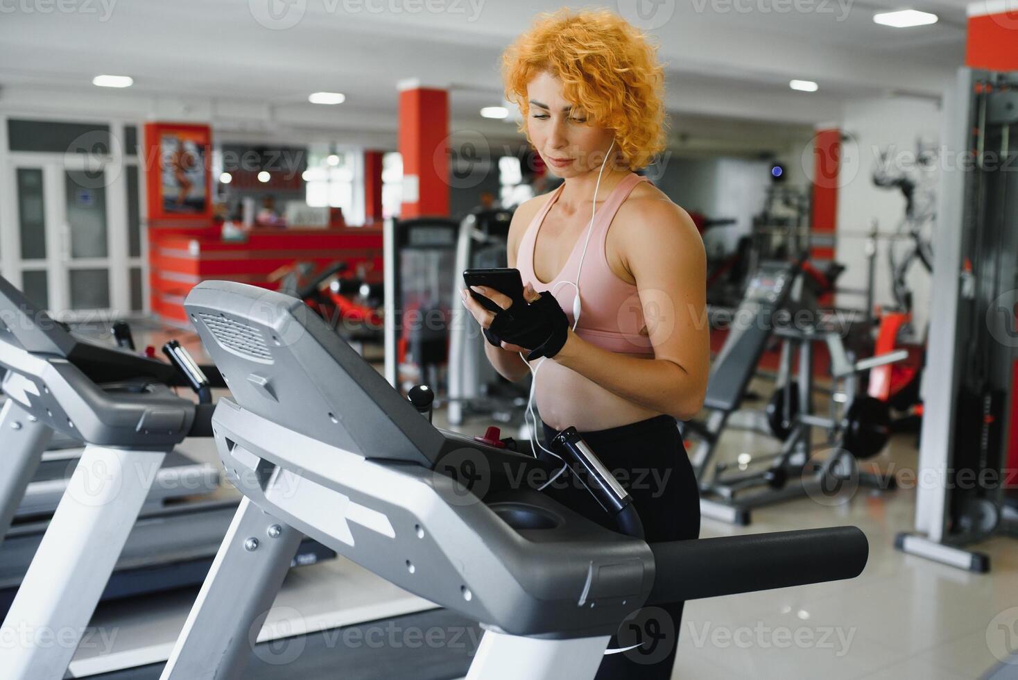 attraktiv jung Frau läuft auf ein Laufband, ist beschäftigt, verlobt im Fitness Sport Verein foto