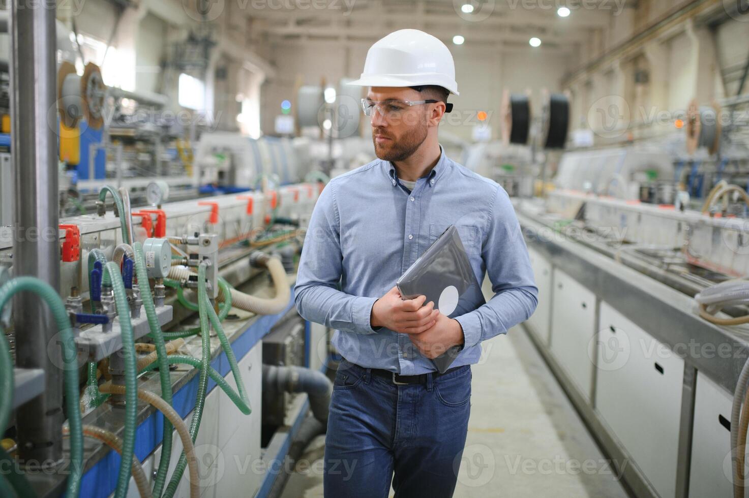 ein jung männlich Ingenieur inspiziert das Produktion von Plastik Fenster Frames foto