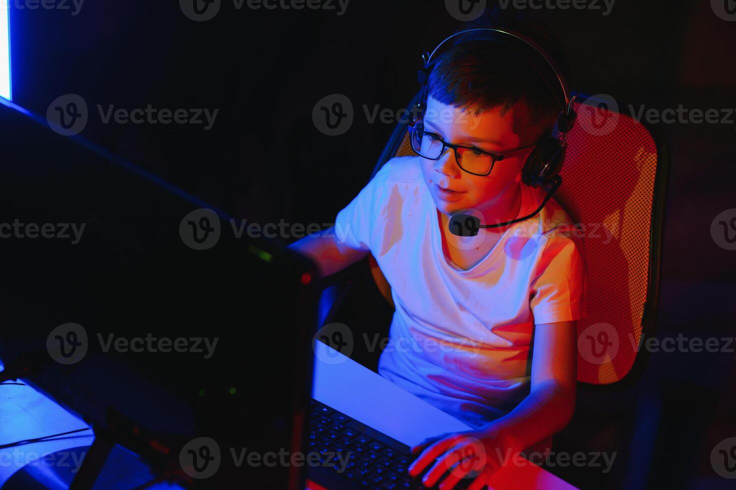 Kind online Sendungen Computer Spiel, Junge Streams im Kopfhörer auf rgb Beleuchtung Hintergrund foto