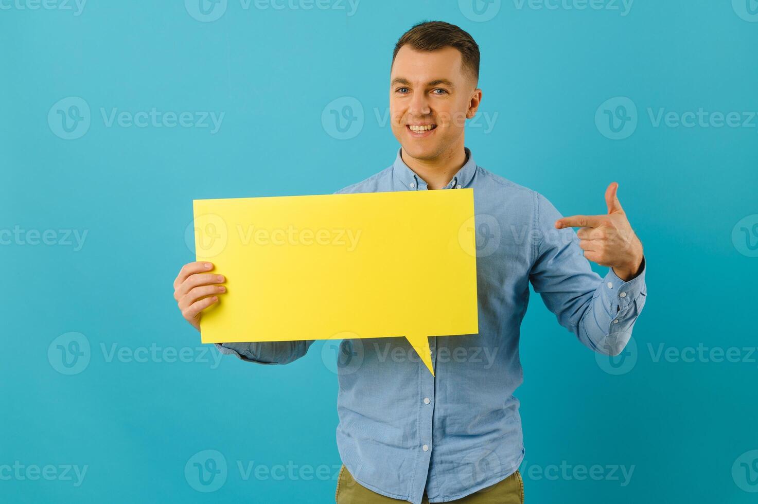 gut aussehend lächelnd Mann halten leer Rede Blase Zeichen isoliert auf Licht Blau Studio Banner Hintergrund mit Kopieren Raum foto