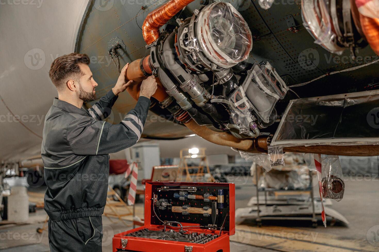 männlich Luftfahrt Mechaniker reparieren Flugzeug im Halle foto