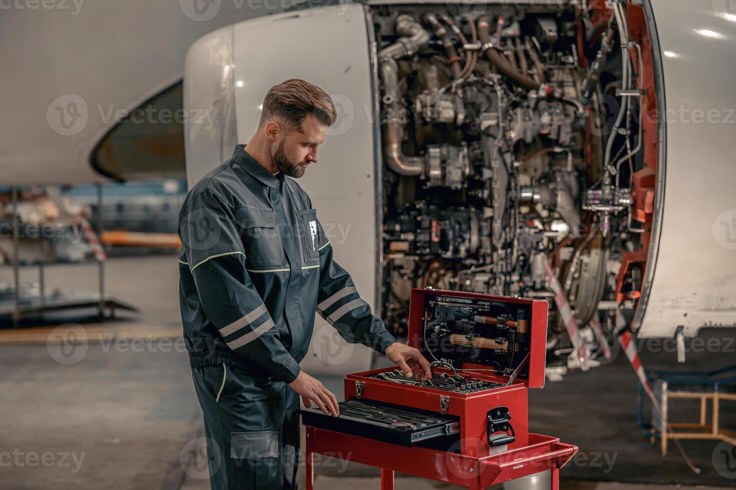 männlich Fluggesellschaft Mechaniker mit Werkzeug Box im Halle foto