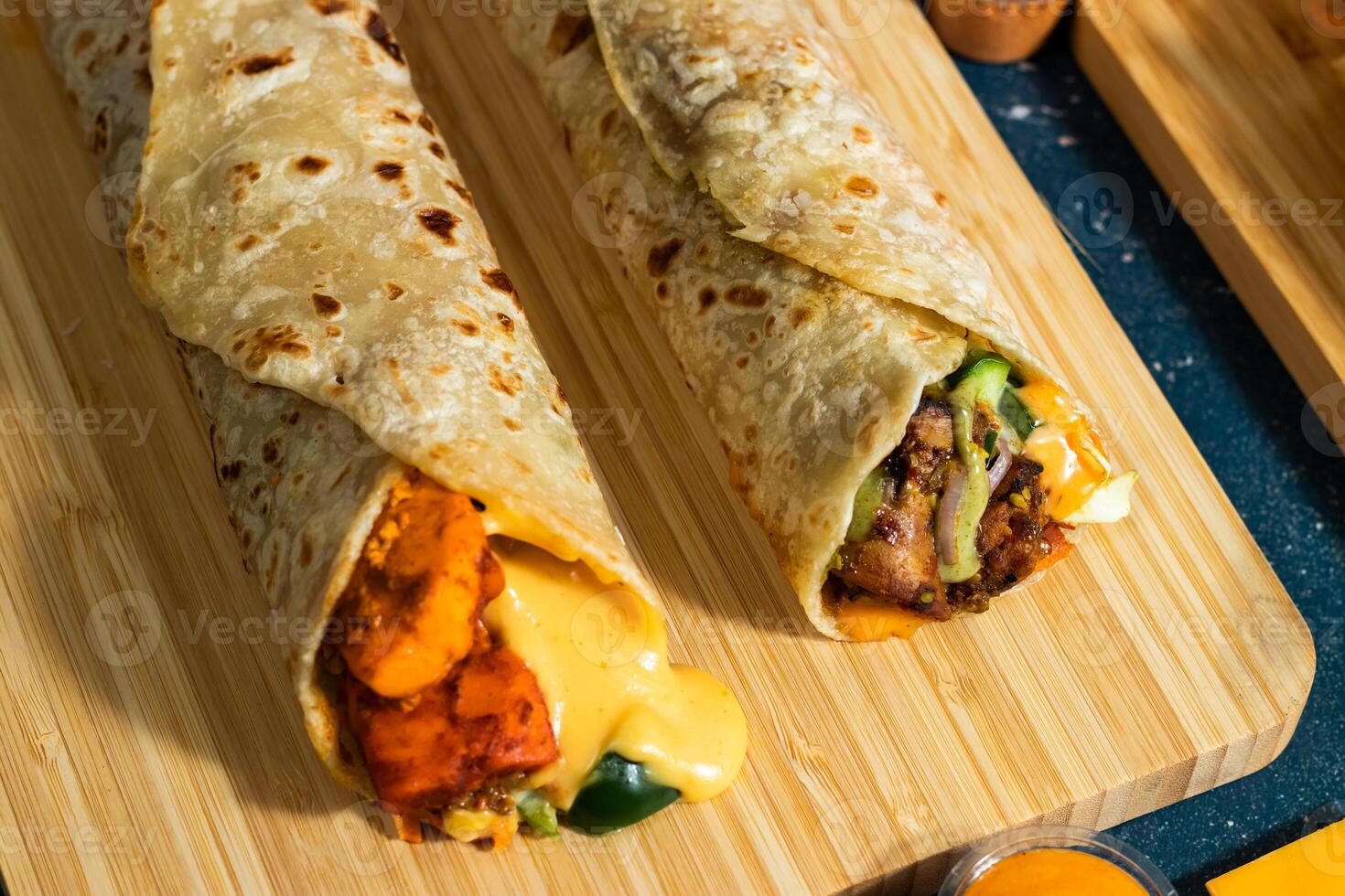 Schmelze Käse Paneer wickeln, Hähnchen afghani Kebab Döner wickeln mit Salat tauchen und Soße isoliert hölzern Tafel Seite Aussicht von Fast Food foto