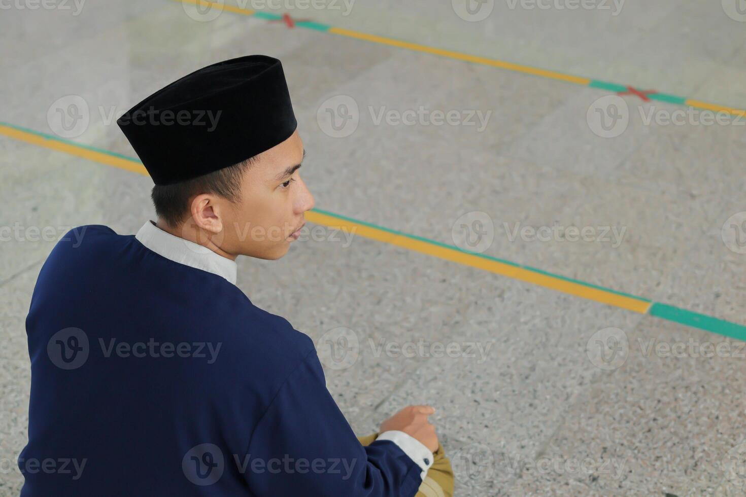 Porträt von religiös asiatisch Mann im Muslim Hemd beten und tun salat oder sholat im Moschee foto