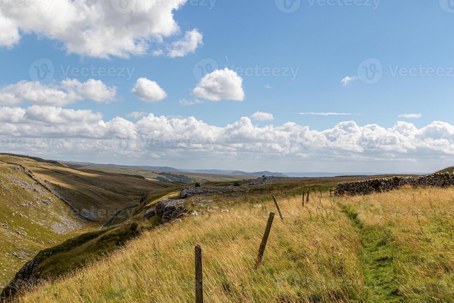 szenisch Landschaft Landschaft mit rollen Hügel, ein klar Himmel, und ein Fußweg begrenzt durch ein Zaun beim Malham Bucht, Yorkshire, Vereinigtes Königreich. foto