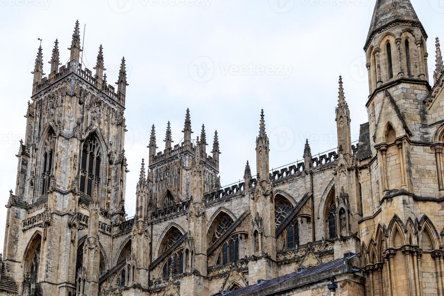 gotisch Kathedrale Fassade mit kompliziert die Architektur und Türme gegen ein wolkig Himmel im York, Norden Yorkshire foto