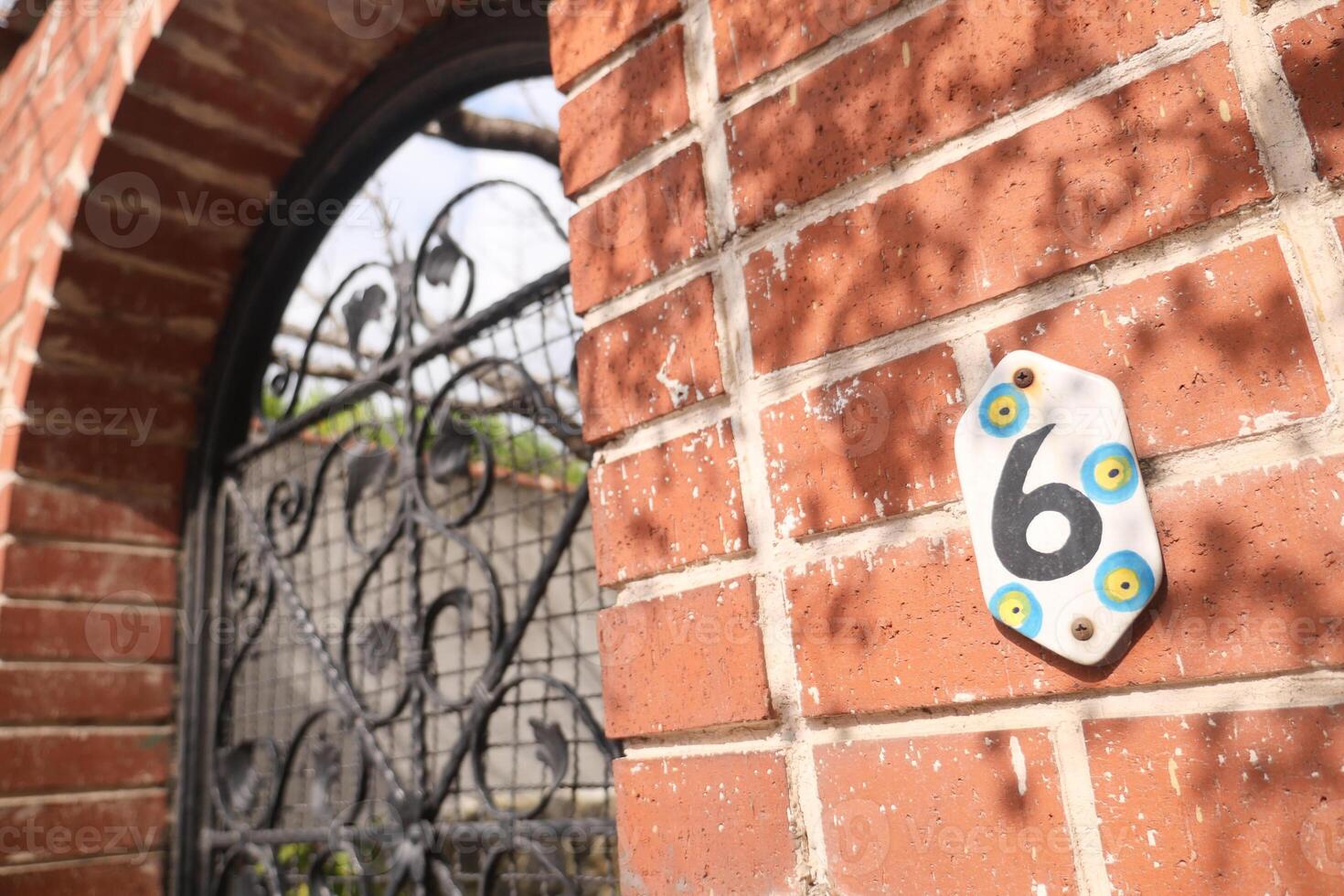 Haus Nummer sechs. dekorativ Beschriftung auf ein Backstein Mauer. foto