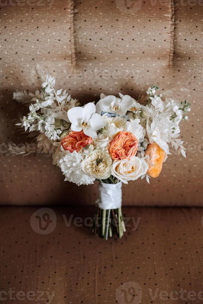 Hochzeit Strauß. frisch Schnitt Rosen, Grün Samen Köpfe und Blätter. Grün Stiele, Weiß Band und Gold Hochzeit Ringe. das Konzept von ein Hochzeit Strauß. foto