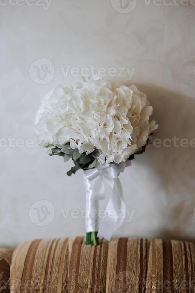 Hochzeit Strauß. frisch Schnitt Rosen, Grün Samen Köpfe und Blätter. Grün Stiele, Weiß Band und Gold Hochzeit Ringe. das Konzept von ein Hochzeit Strauß. foto