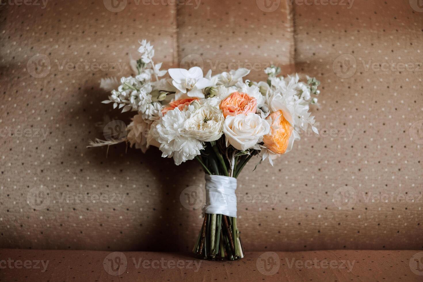 Hochzeit Strauß. frisch Schnitt Rosen, Grün Samen Köpfe und Blätter. Grün Stiele, Weiß Band und Gold Hochzeit Ringe. das Konzept von ein Hochzeit Strauß. foto