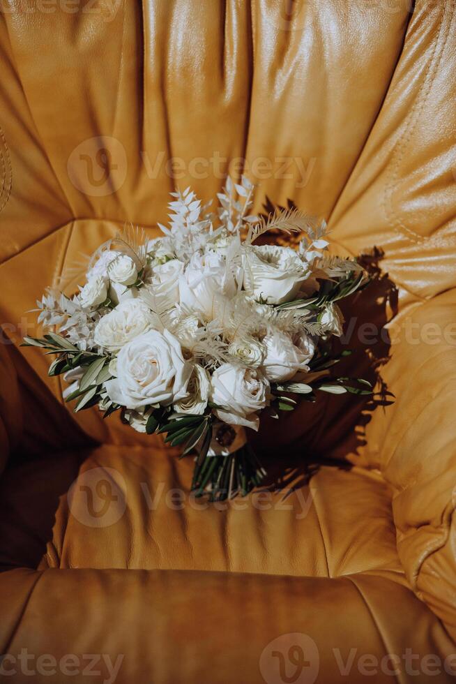 Hochzeit Strauß. frisch Schnitt Rosen, Grün Samen Köpfe und Blätter. Grün Stiele, Weiß Band und Gold Hochzeit Ringe. das Konzept von ein Hochzeit Strauß. foto