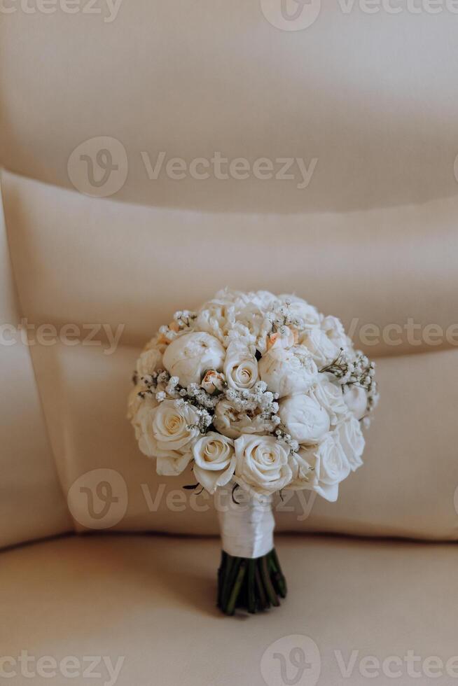 Hochzeit Strauß. frisch Schnitt Rosen, Grün Samen Köpfe und Blätter. Grün Stiele, Weiß Band und Gold Hochzeit Ringe. das Konzept von ein Hochzeit Strauß. foto