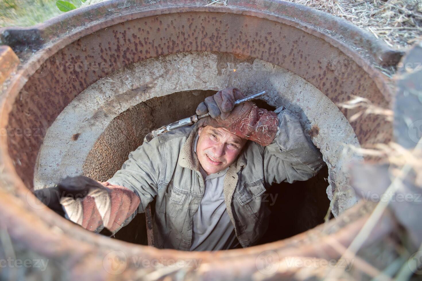 Abwasser funktioniert. industriell Abwasser Behandlung. ein Arbeiter im ein Kanal Luke mit ein Installation Taste. foto