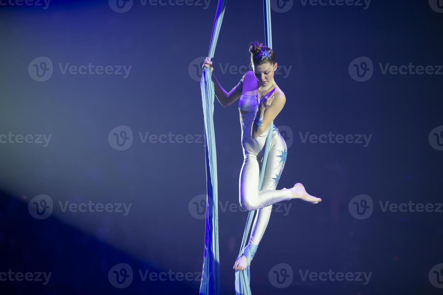 Performance durch ein Zirkus Akrobat Künstler. Mädchen ausführen Antenne akrobatisch Elemente auf Stoff. foto