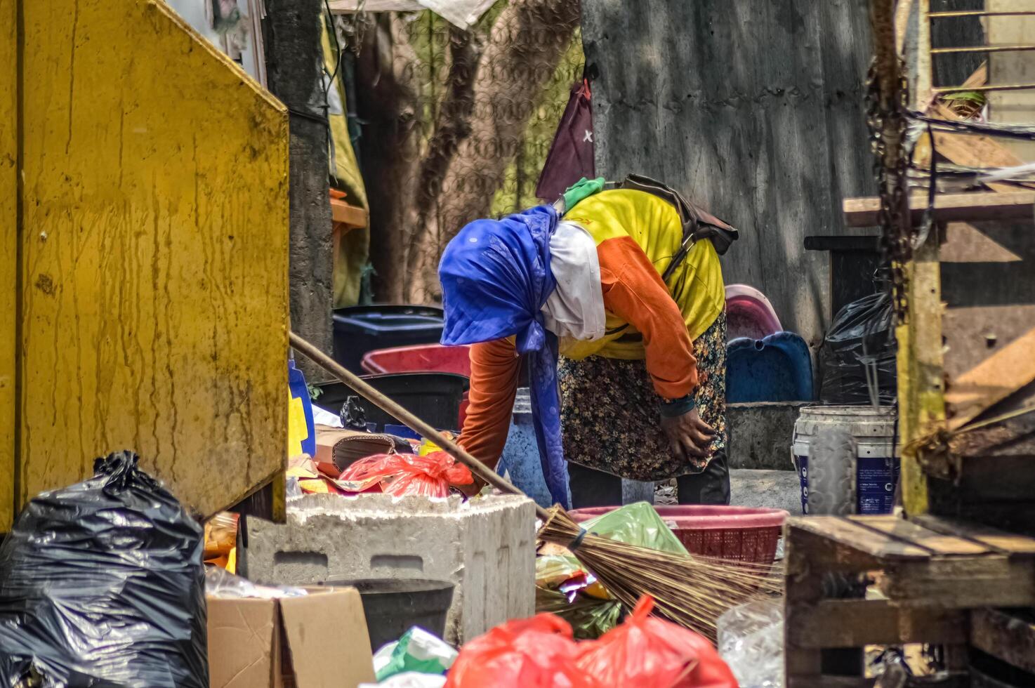 ein Assgeier Wer ist Sortierung Müll beim ein vorübergehend Müll Unterschlupf, Indonesien, 2 November 2023. foto