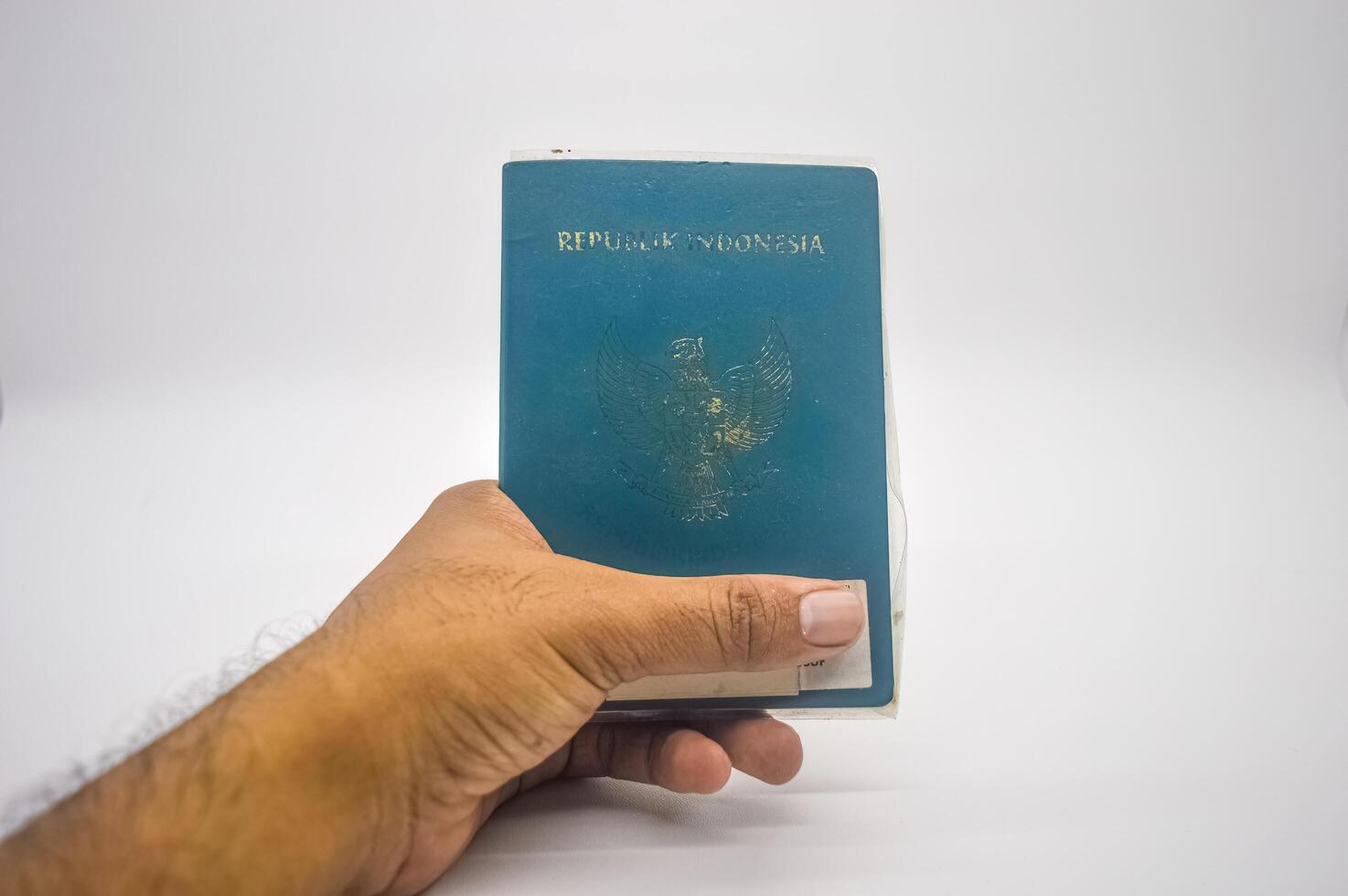 Hand halten ein indonesisch Reisepass isoliert auf ein Weiß Hintergrund, Indonesien, 2 Januar 2024. foto
