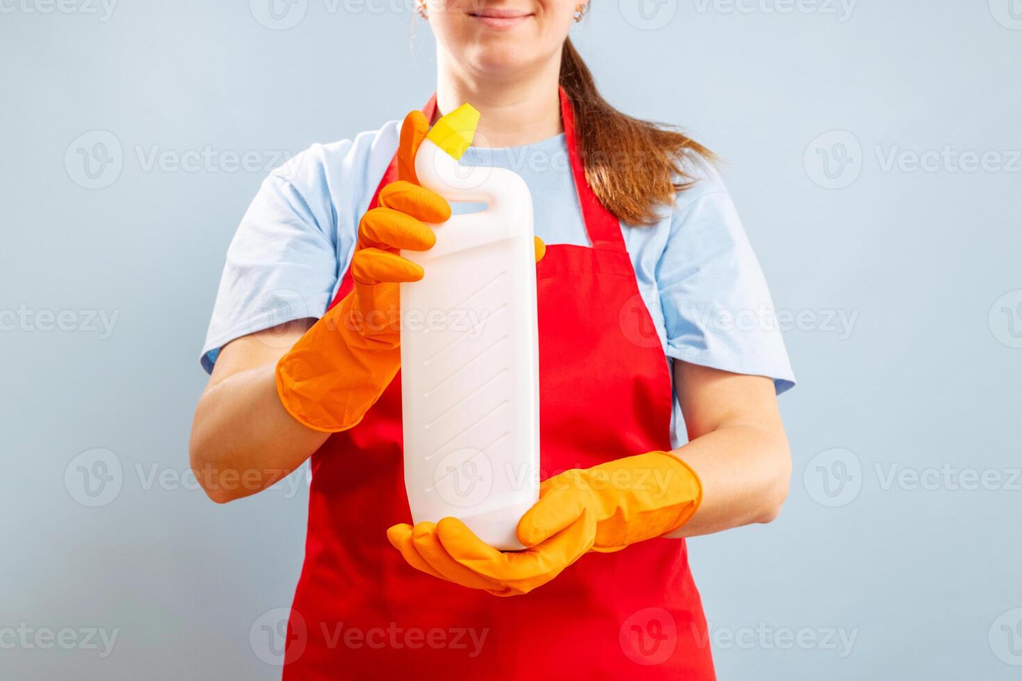 Frau im Handschuh halten ein Plastik Waschmittel Flasche auf Blau Hintergrund foto