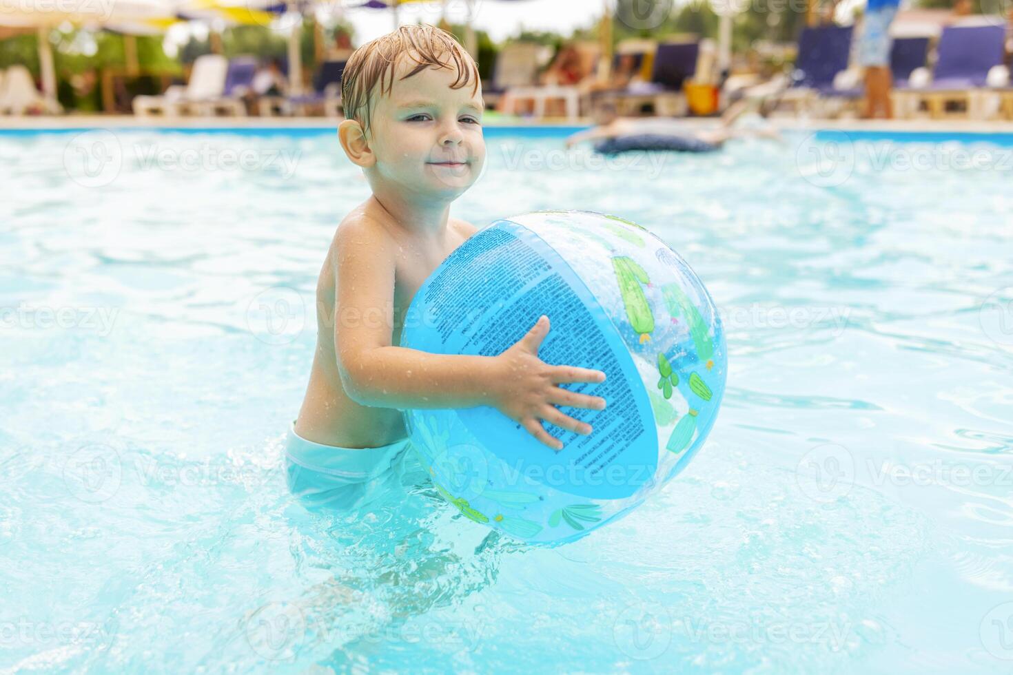 Kind schwimmen, tauchen, Freizeit und spielen aufblasbar Ball im Schwimmbad beim Ferien foto