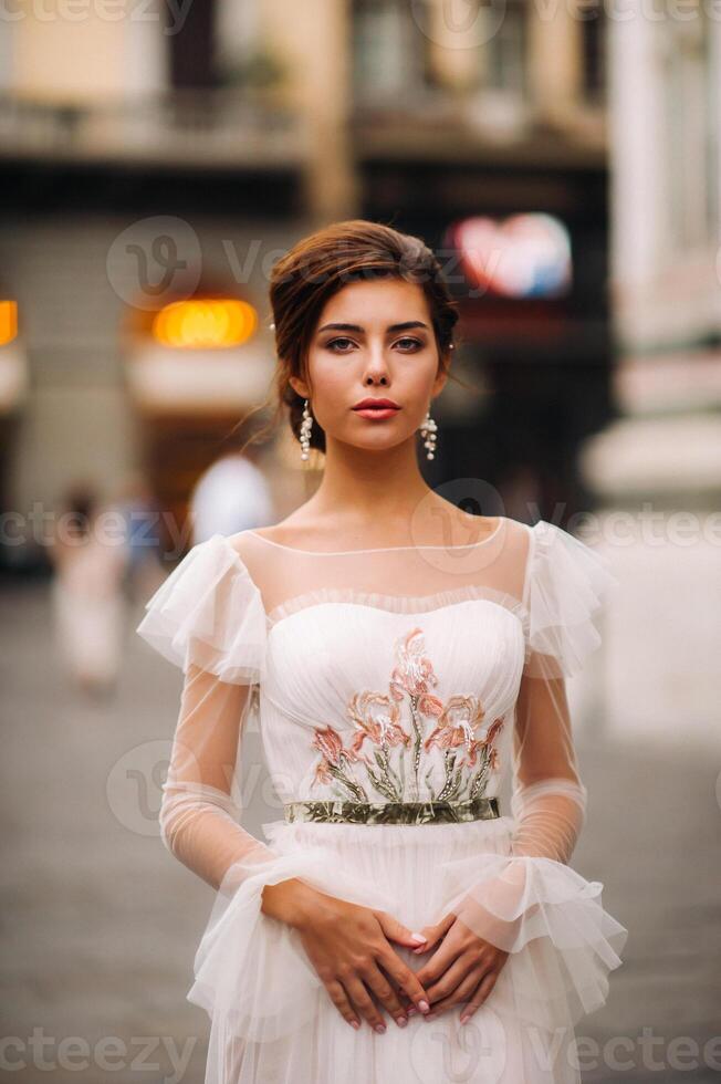 Mädchen-Braut Hochzeit Kleid mit ein schön Blumen- Muster im Florenz, stilvoll Braut im ein Hochzeit Kleid steht im das alt Stadt von Italien. Modell- Mädchen im Florenz foto