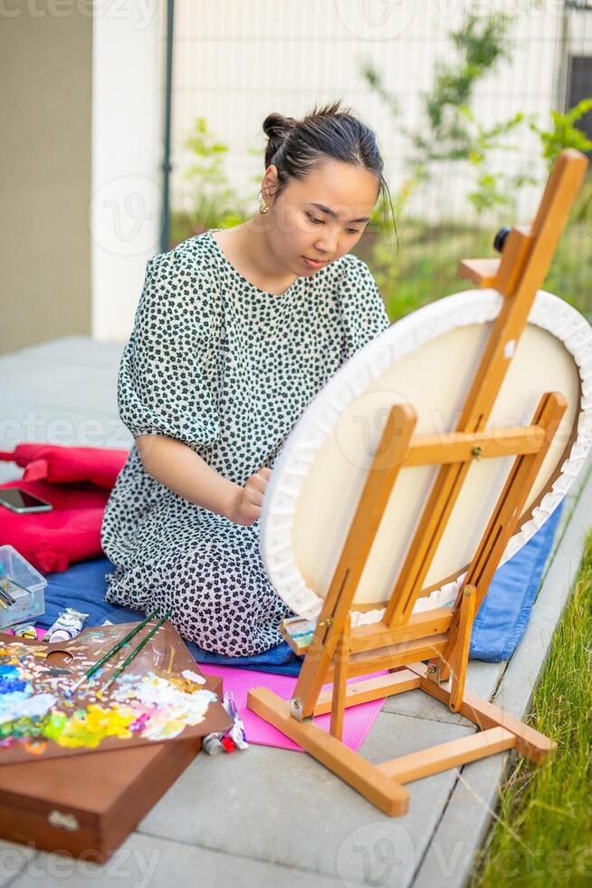 asiatisch jung Frau Gemälde Bild von Zitronen auf Blau Decke im Zuhause Terrasse. hoch Qualität Foto