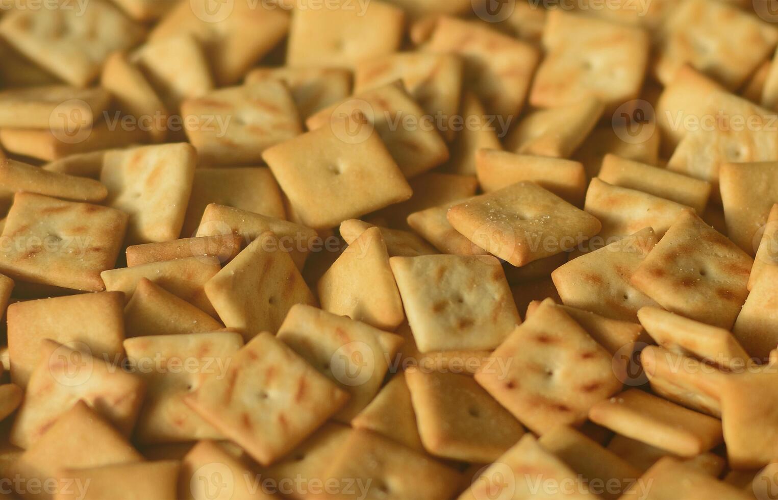 Viele kleine Kekse sind quadratisch. ein Muster eines gelben Salzcrackers. Hintergrundbild mit Salzgebäck foto