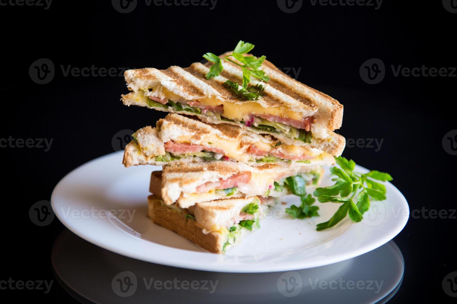 gebraten Toast ausgestopft mit Wurst, Käse und Grüns innen, auf schwarz Hintergrund. foto