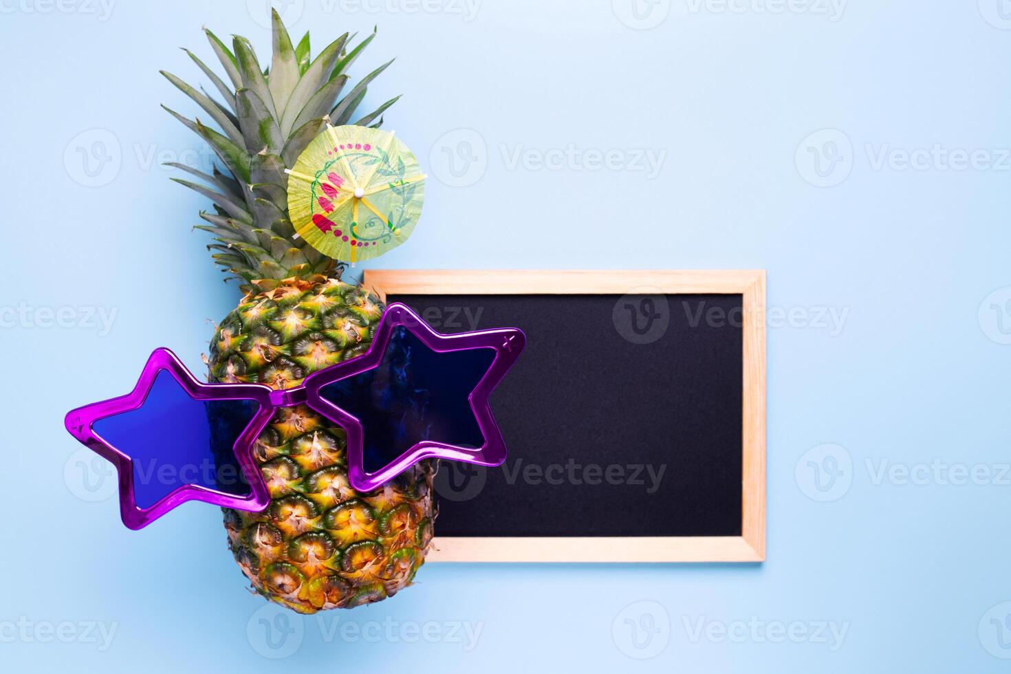 Ananas im Sonnenbrille mit leeren Tafel zum Ihre Text auf Blau Hintergrund foto