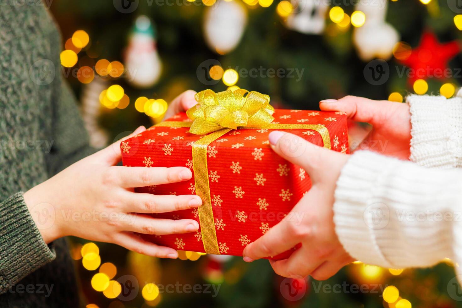 Hände von Elternteil geben Weihnachten Geschenk zu Kind auf Weihnachten Baum Hintergrund foto