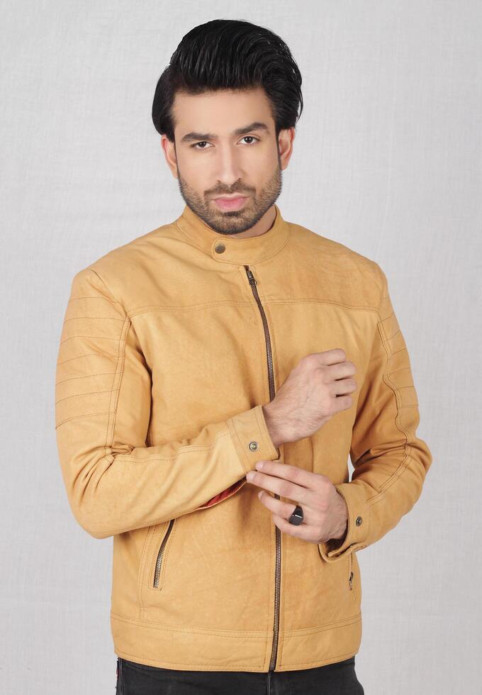 Studio Schuss von jung gut aussehend indisch Mann tragen braun Leder Jacke gegen Weiß Hintergrund foto