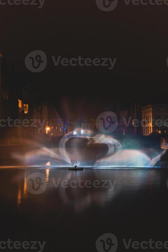 Weihnachten Licht Show im das bilden von das Schwan tanzen auf das Wasser Kanal im das historisch Kreis im Brügge, Belgien. romantisch Szene foto