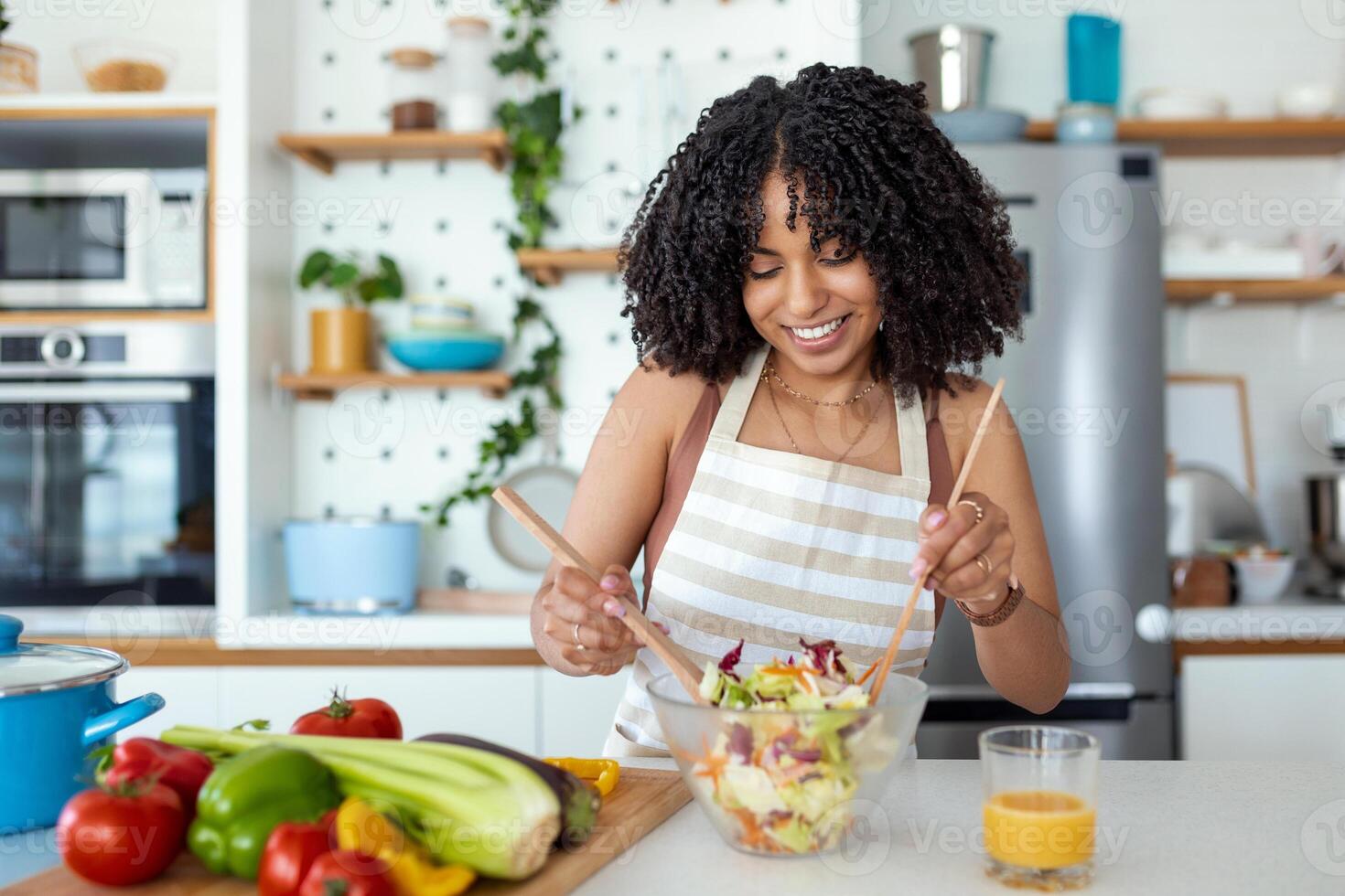 gesund Lebensstil. gut Leben. organisch Lebensmittel. Gemüse. schließen oben Porträt von glücklich süß schön jung Frau während sie Versuchen lecker vegan Salat im das Küche beim heim. foto