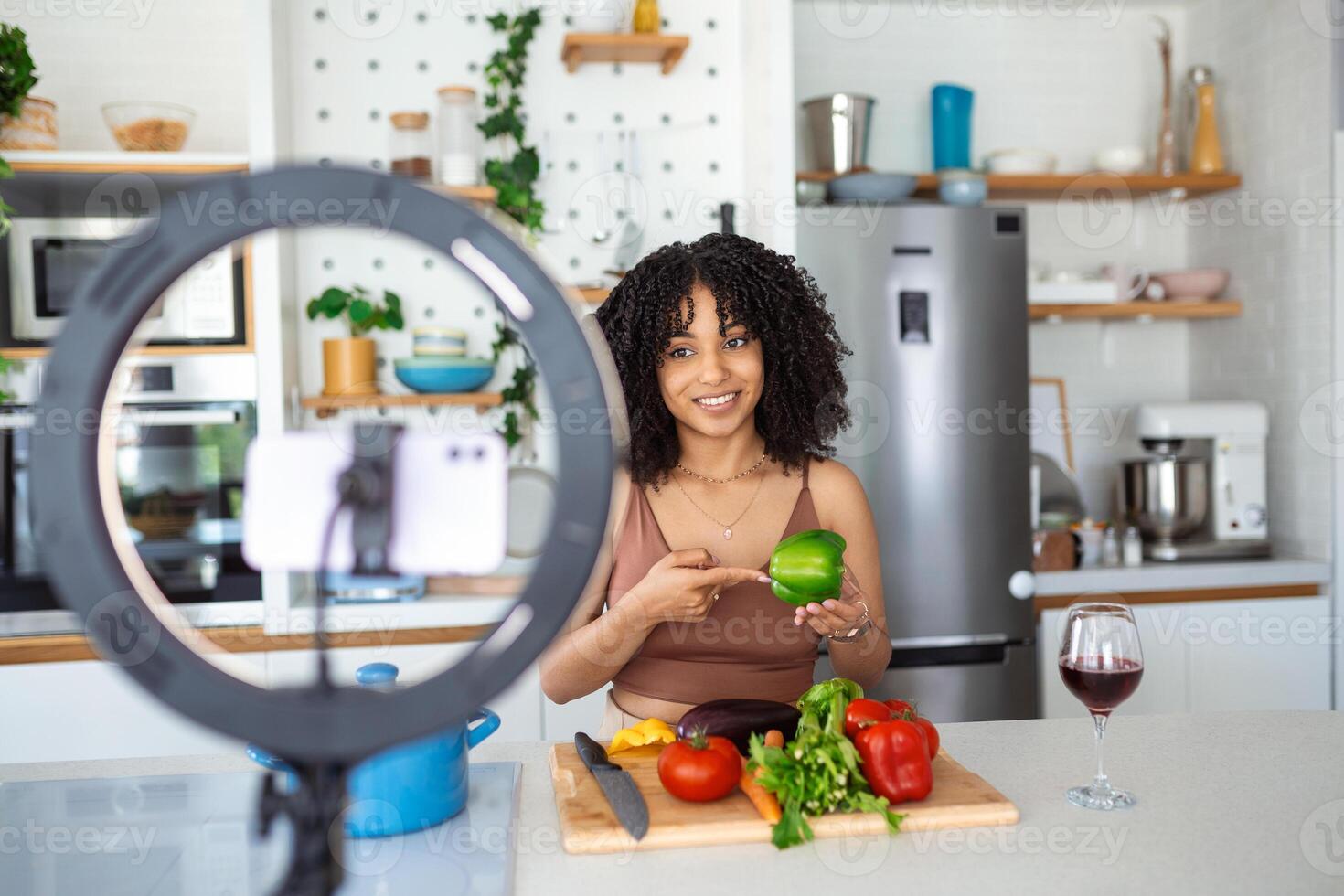 jung afrikanisch amerikanisch Frau Kochen Lautsprecher reden auf Digital Kamera Aufzeichnung vlog. afrikanisch Frau vlogger oder Schießen Blog filmen Reportage Werbung Video, Coaching. foto