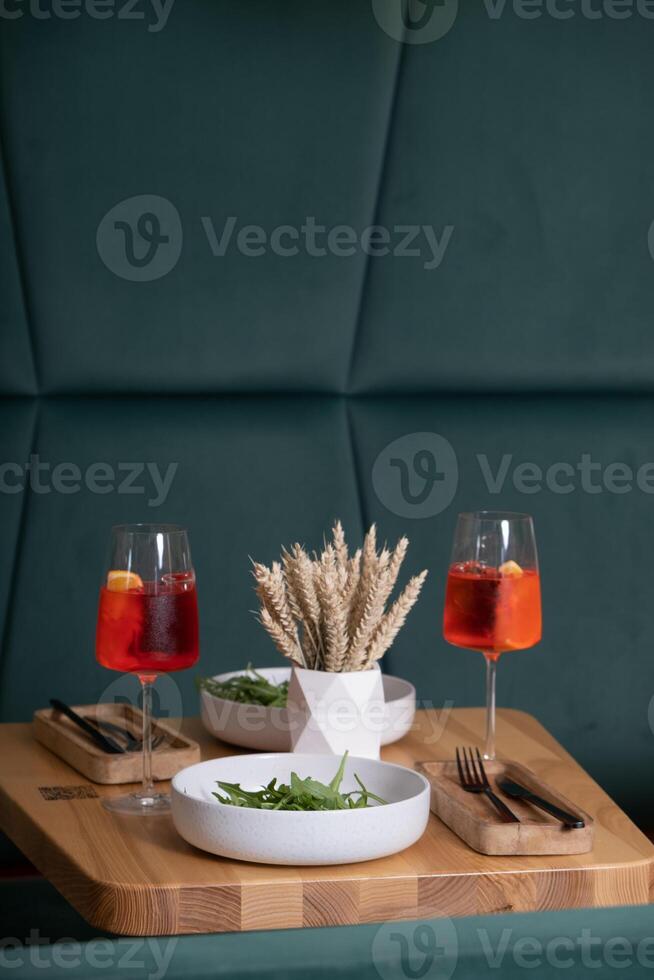 Tabelle mit Geschirr und Cocktails im ein Cafeteria zum zwei. Abendessen oder Datum Konzept foto