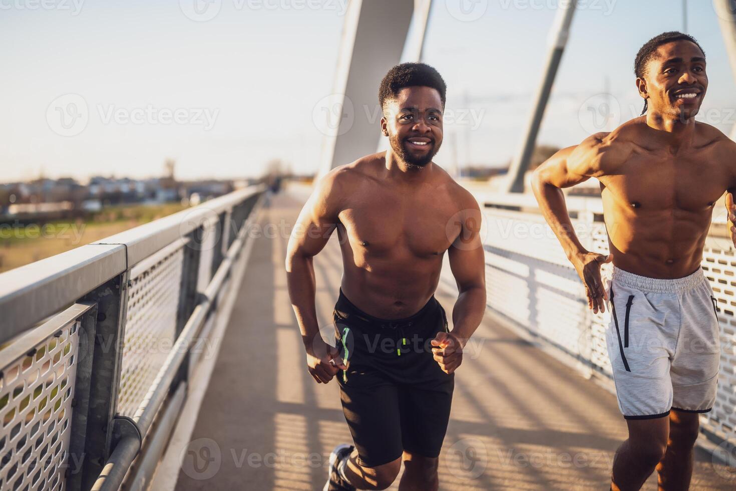 zwei Afroamerikaner freunde sind Joggen auf das Brücke im das Stadt. foto