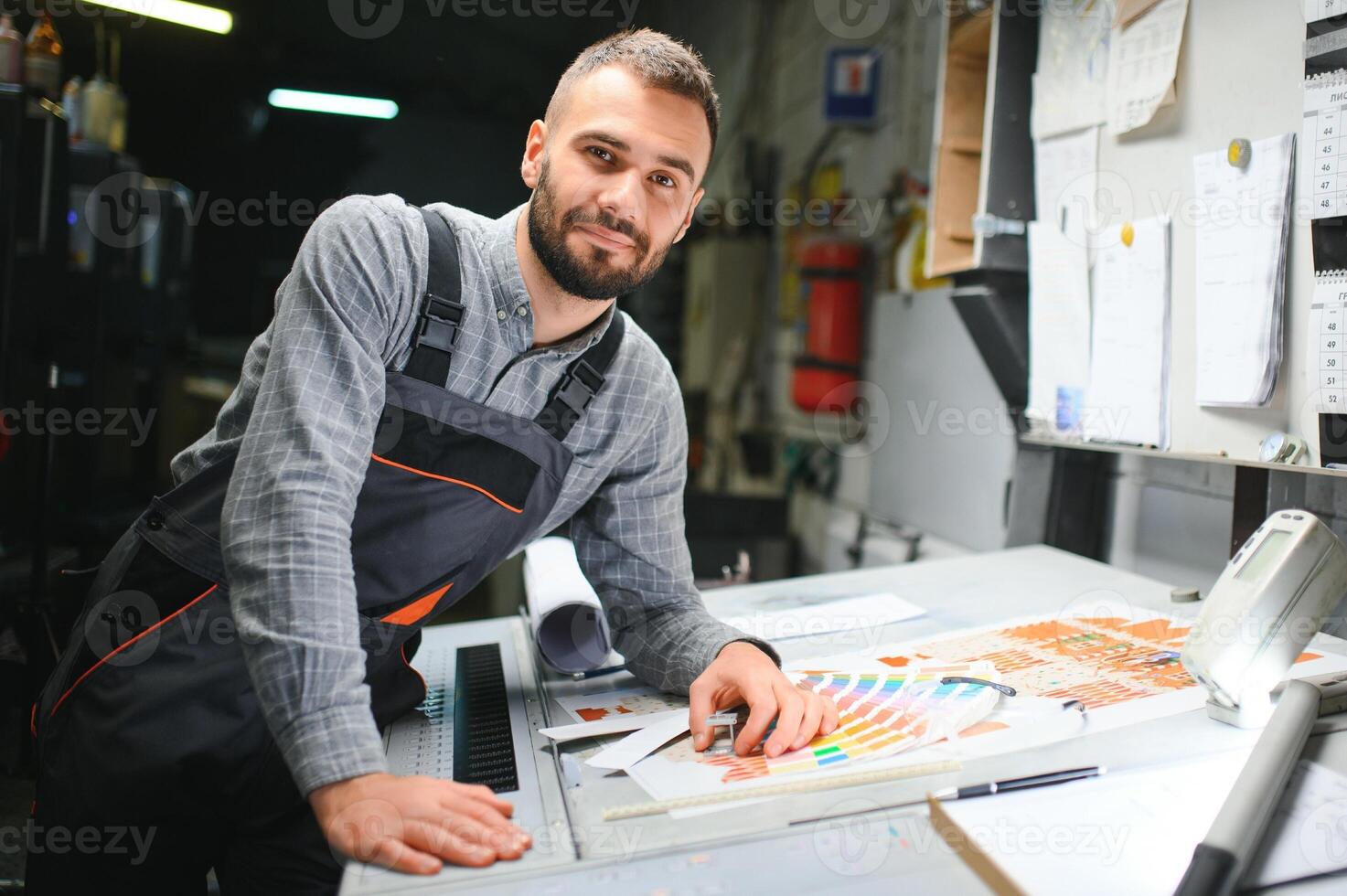 drucken Haus Arbeiter steuern Drucken Prozess Qualität und Überprüfung Farben mit Vergrößerung Glas foto