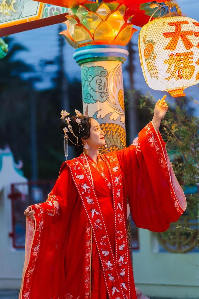 Frau Kleid China Neu Jahr. Porträt von ein Frau. Person im traditionell Kostüm. Frau im traditionell Kostüm. schön jung Frau im ein hell rot Kleid und ein Krone von Chinesisch Königin posieren. foto