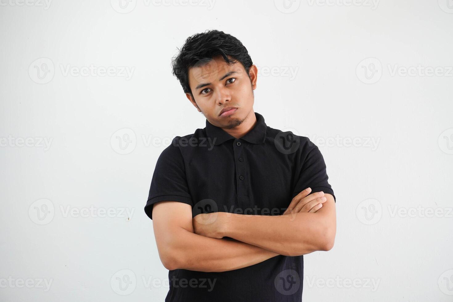 jung asiatisch Mann im beiläufig schwarz Polo t Hemd mit Arm gekreuzt müde von ein repetitiv Aufgabe suchen beim Kamera Studio Schuss isoliert auf Weiß Hintergrund foto