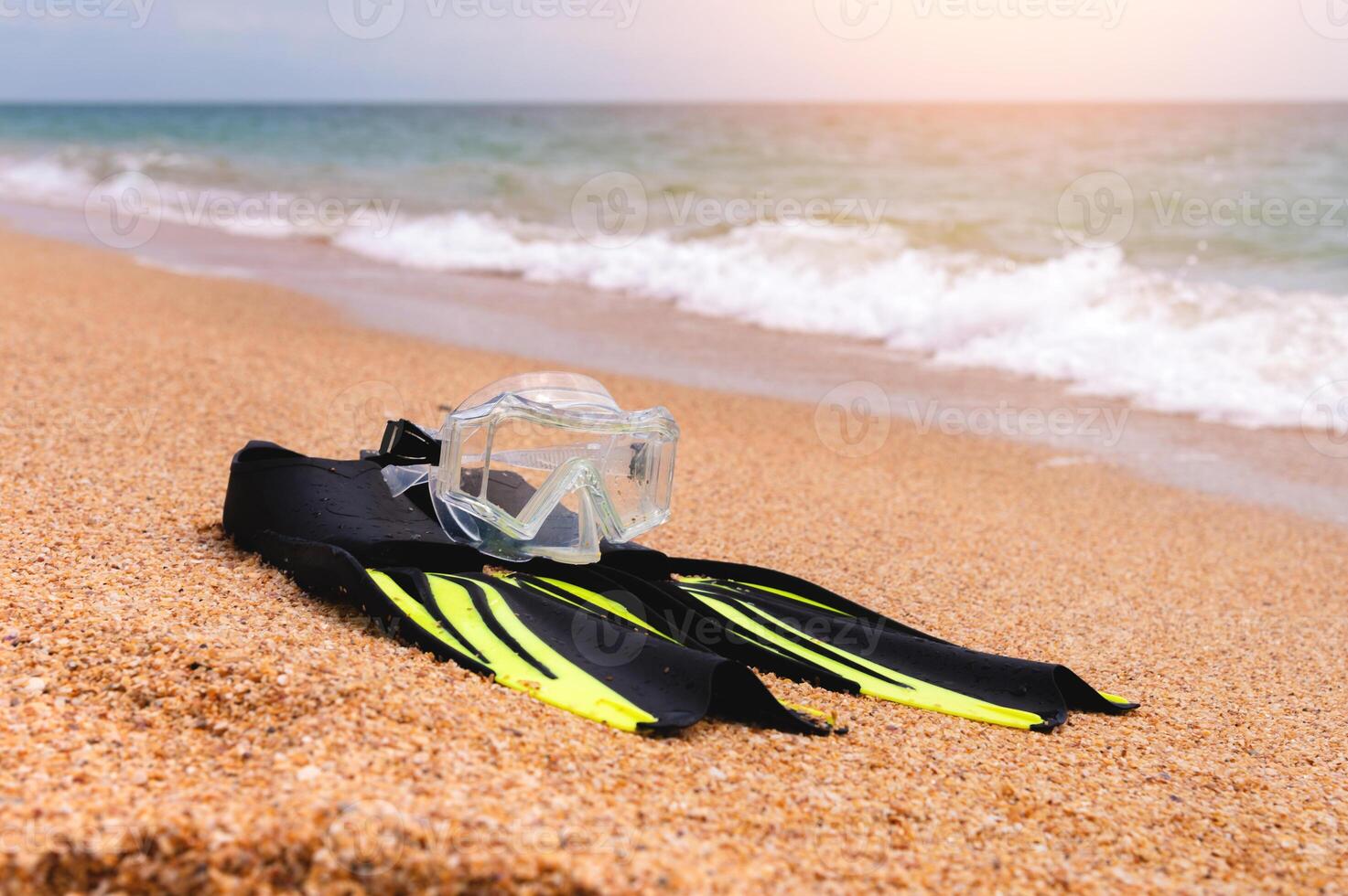 flach Tiefe von Feld Schnorcheln Maske mit Flossen Lügen auf ein sandig Strand mit Blick auf das Meer und Himmel, Nein Menschen foto