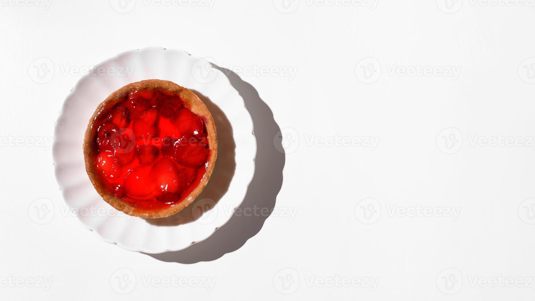 Käsekuchen mit Erdbeeren im Sirup auf ein Platte, Weiß Tabelle Hintergrund. Essen Banner. eben legen, oben Sicht, Kopieren Raum. foto