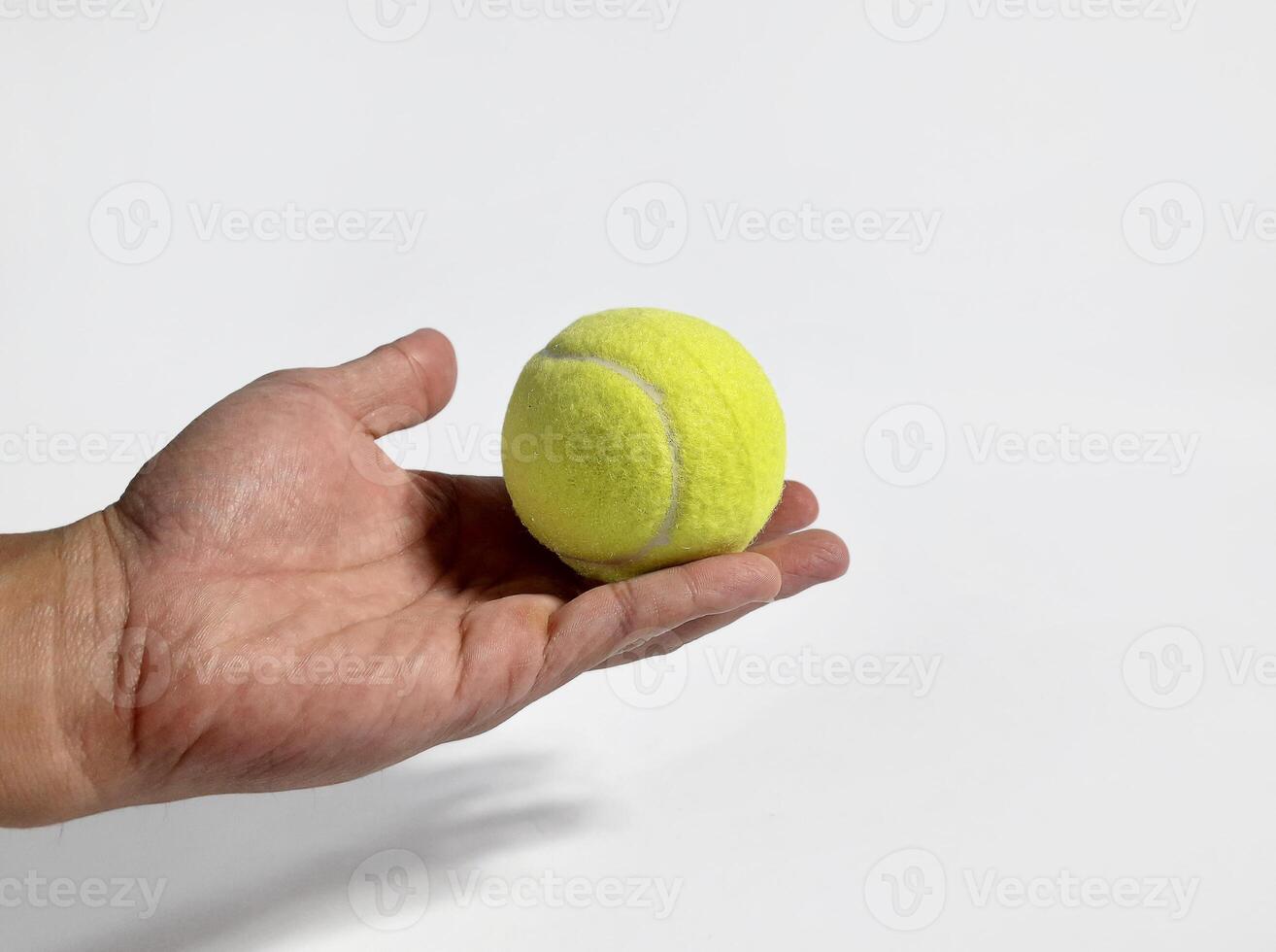 ein Tennis Ball gehaltenen durch ein asiatisch Mann foto