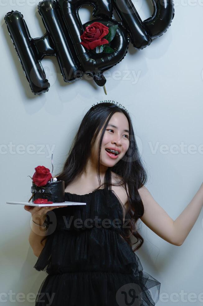 schön Frau tragen ein schwarz Kleid und Schokolade Kuchen im das Konzept von Geburtstag foto