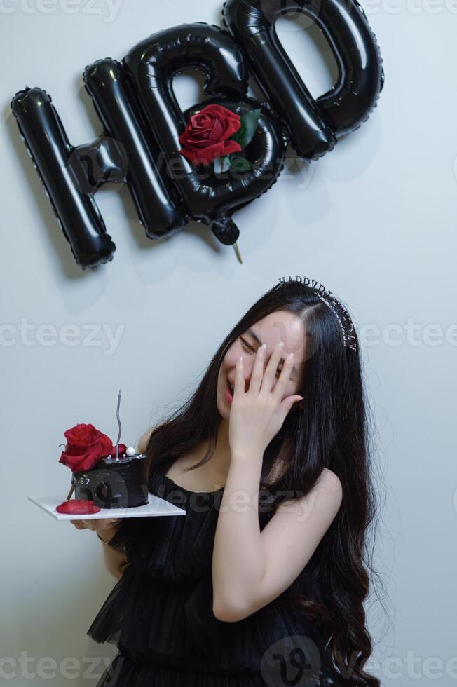 schön Frau tragen ein schwarz Kleid und Schokolade Kuchen im das Konzept von Geburtstag foto
