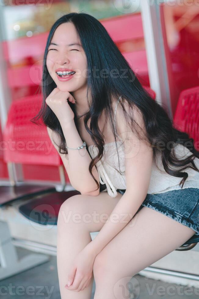 schön asiatisch Frau posiert im Mode Stil, Weiß Shirt, Jeans Rock. foto